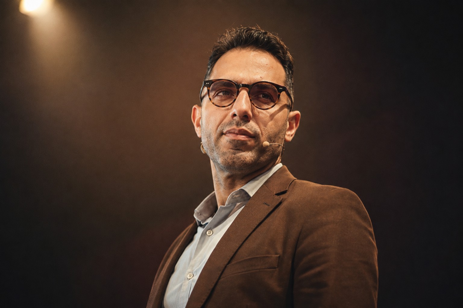 Mohamed Nabil in a brown blazer on stage